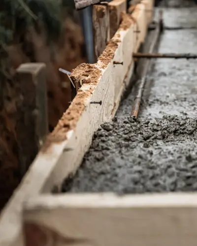 Coulage de béton dans un coffrage en bois pour fondation de structure